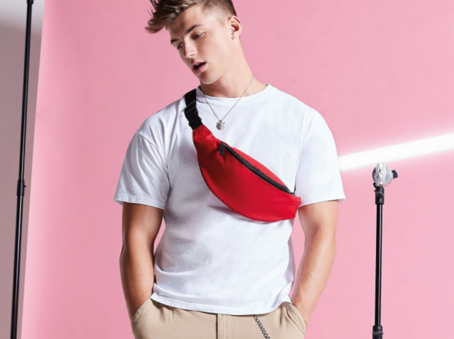 Homme portant un sac banane rouge sacs BagBase personnalisés.