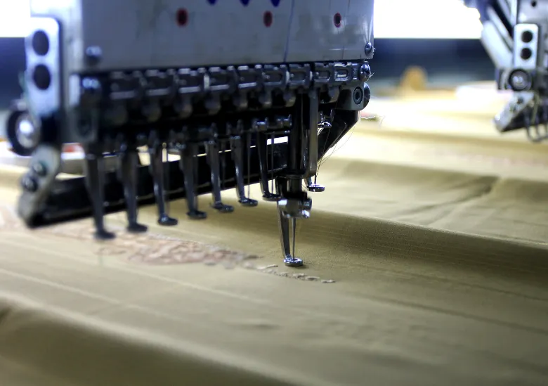 Machine de broderie en production avec fils de broderie colorés - atelier Koaprint