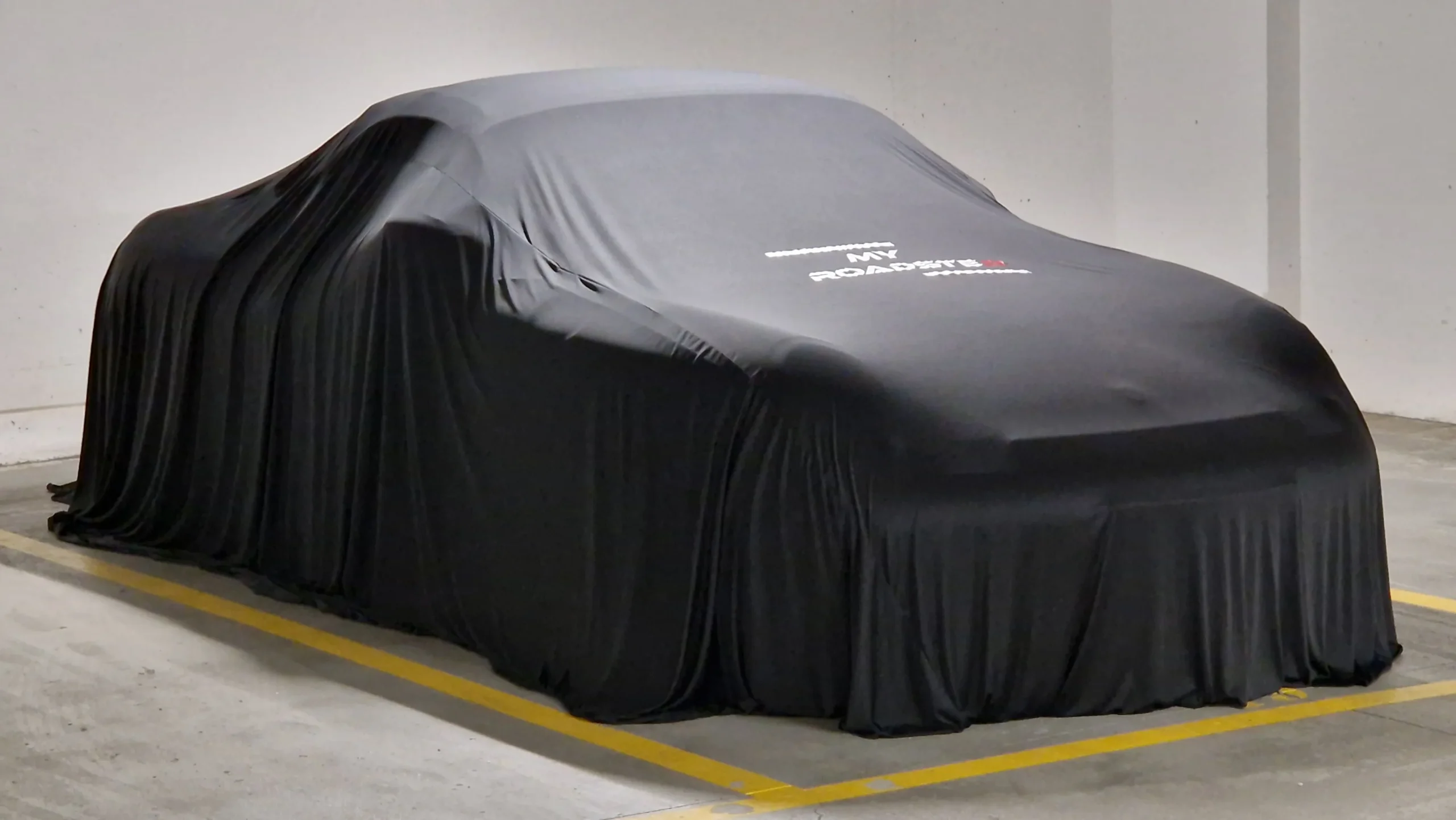 Aston Martin DBX sous housse textile personnalisée My Roadster devant le Pont Neuf à Paris